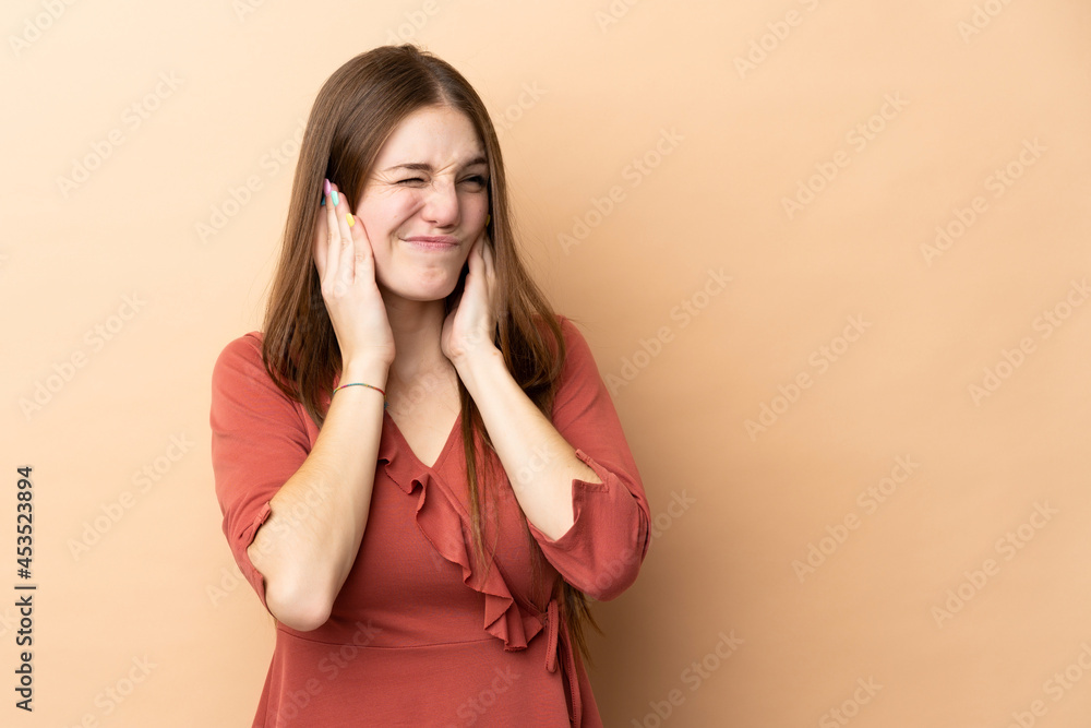 Young caucasian woman isolated on beige background frustrated and covering ears Young caucasian woman isolated on beige background frustrated and covering ears