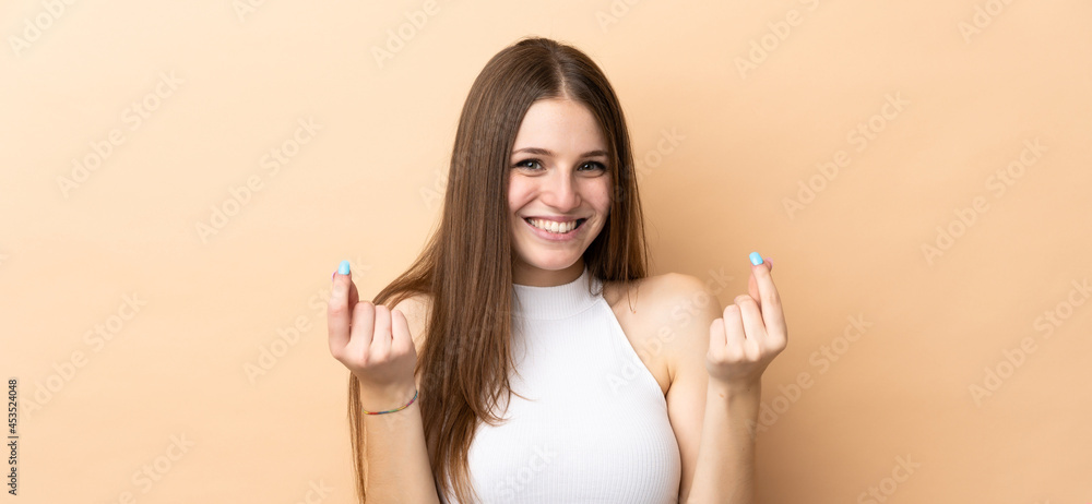 Young caucasian woman isolated on beige background making money gesture Young caucasian woman isolated on beige background making money gesture