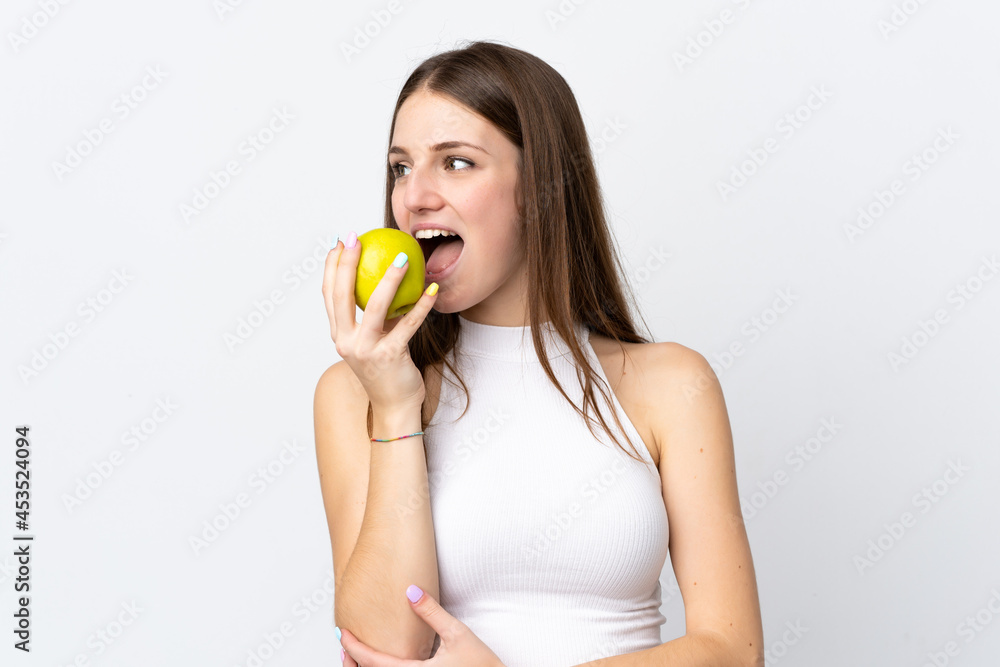 Young caucasian woman isolated on white background eating an apple Young caucasian woman isolated on white background eating an apple