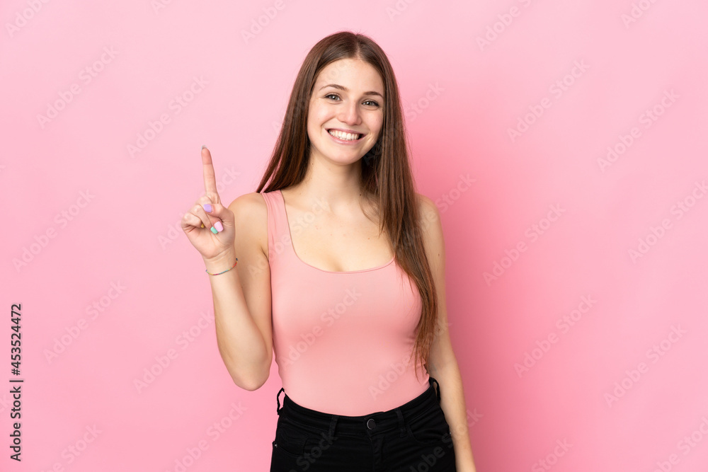 Young caucasian woman isolated on pink background showing and lifting a finger in sign of the best Young caucasian woman isolated on pink background showing and lifting a finger in sign of the best