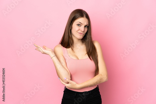 Fototapeta Naklejka Na Ścianę i Meble -  Young caucasian woman isolated on pink background having doubts