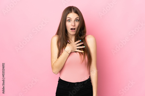 Young caucasian woman isolated on pink background surprised and shocked while looking right