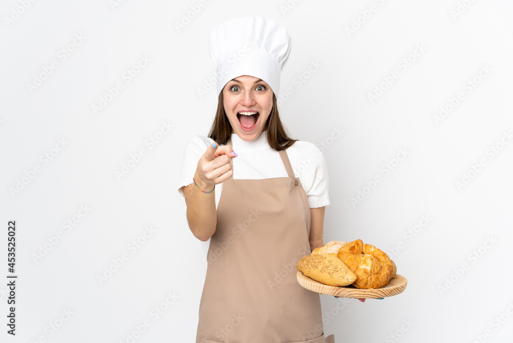 Young woman in chef uniform isolated on white background points finger at you Young woman in chef uniform isolated on white background points finger at you