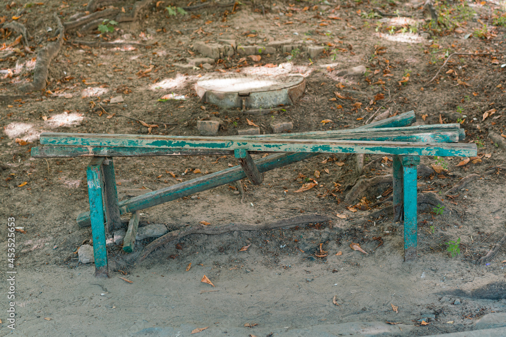 Green broken bench outdoor. Street. Park. Vandals. Wooden. Ground. Damage. Damaged Green broken bench outdoor. Street. Park. Vandals. Wooden. Ground. Damage. Damaged