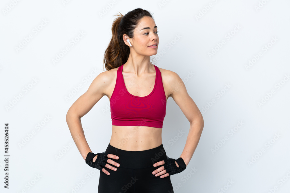 Sport woman over isolated white background posing with arms at hip and looking side Sport woman over isolated white background posing with arms at hip and looking side