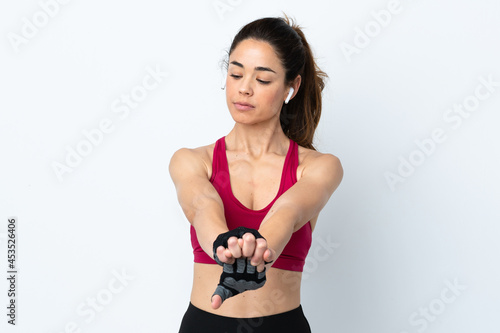 Sport woman over isolated white background stretching arm