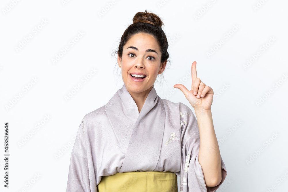 Woman wearing kimono over isolated background intending to realizes the solution while lifting a finger up Woman wearing kimono over isolated background intending to realizes the solution while lifting a finger up