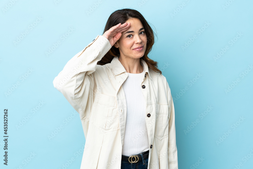 Woman over isolated background saluting with hand with happy expression Woman over isolated background saluting with hand with happy expression