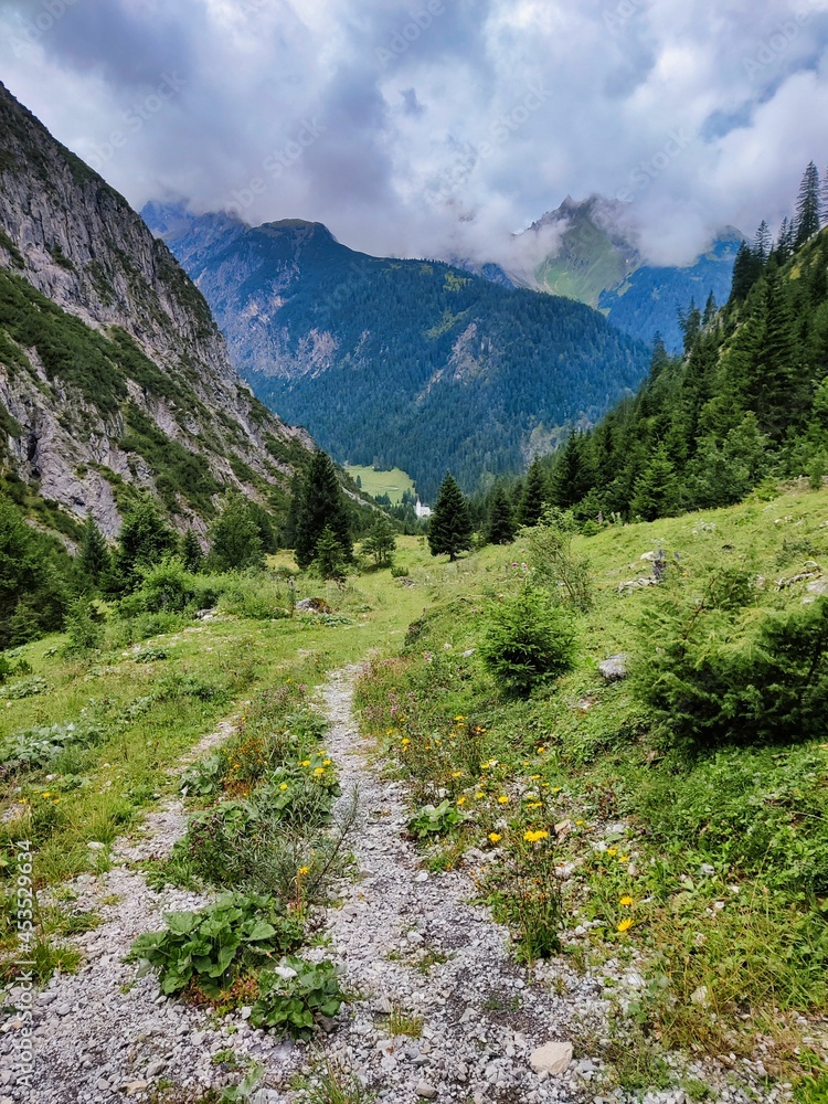 Wandern in die Höhen der Alpen in Österreich Richtung Kogelsee. In der Ferne ist Gramais mit seiner Kirche zu erkennen