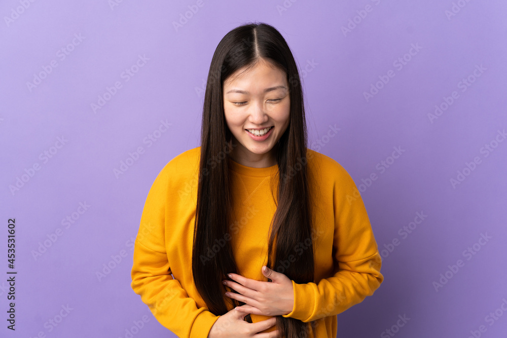 Young Chinese girl over isolated purple background smiling a lot Young Chinese girl over isolated purple background smiling a lot