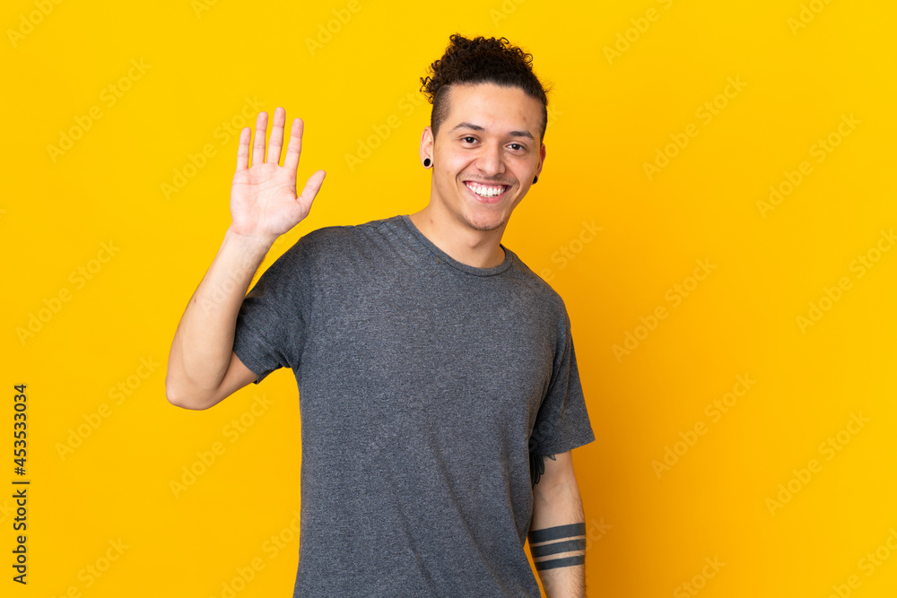 Caucasian man over isolated background saluting with hand with happy expression Caucasian man over isolated background saluting with hand with happy expression