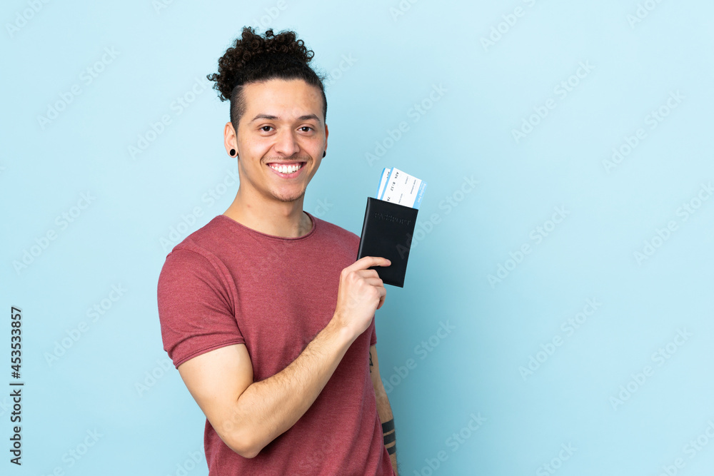 Caucasian man over isolated blue background happy in vacation with passport and plane tickets Caucasian man over isolated blue background happy in vacation with passport and plane tickets