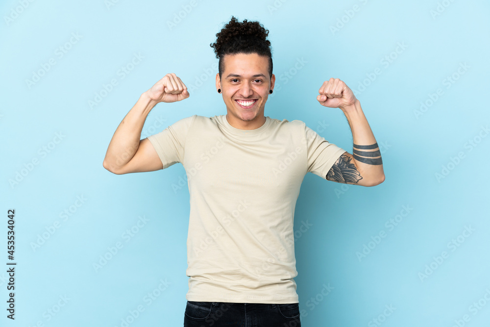 Caucasian man over isolated background doing strong gesture Caucasian man over isolated background doing strong gesture