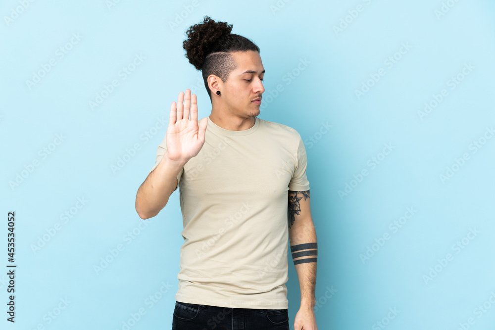 Caucasian man over isolated background making stop gesture and disappointed Caucasian man over isolated background making stop gesture and disappointed