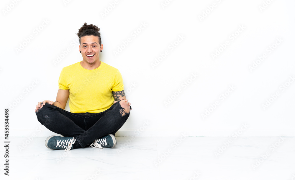 Caucasian man sitting on the floor with surprise facial expression Caucasian man sitting on the floor with surprise facial expression