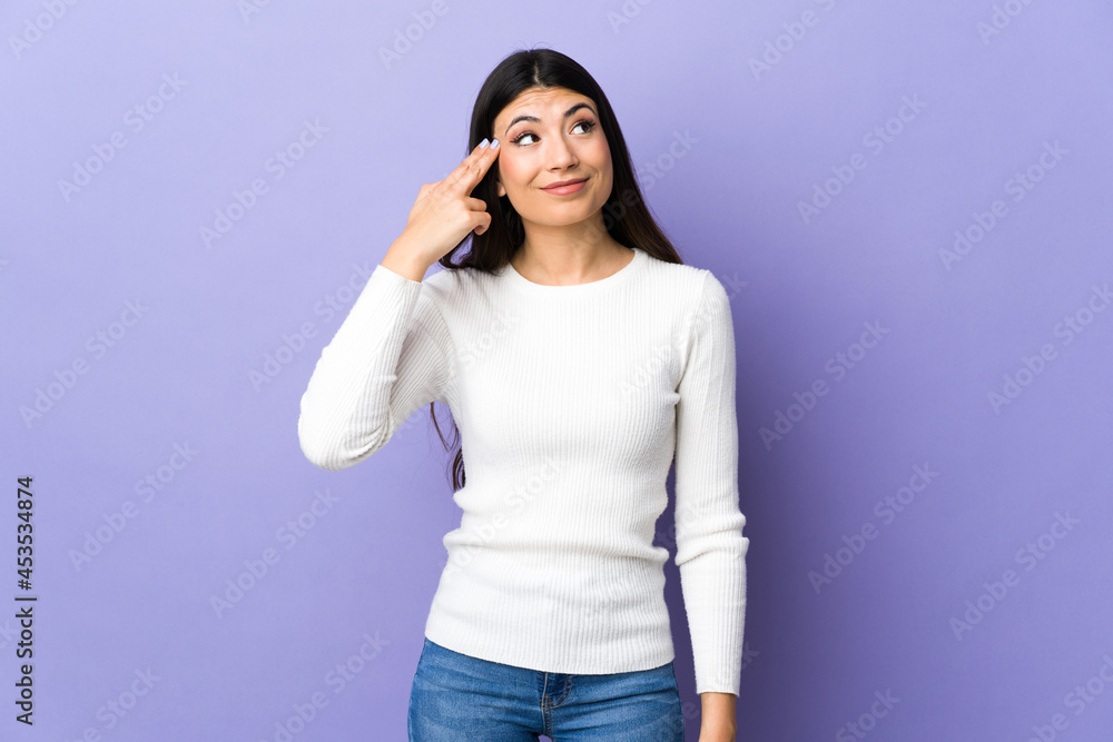 Young brunette woman over isolated purple background with problems making suicide gesture Young brunette woman over isolated purple background with problems making suicide gesture