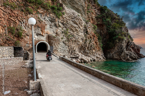 Travelers enter the tunnel on a motorcycle photo