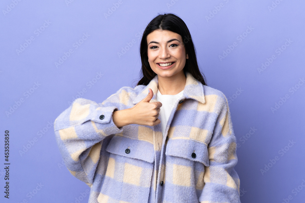 Young brunette woman over isolated purple background giving a thumbs up gesture Young brunette woman over isolated purple background giving a thumbs up gesture