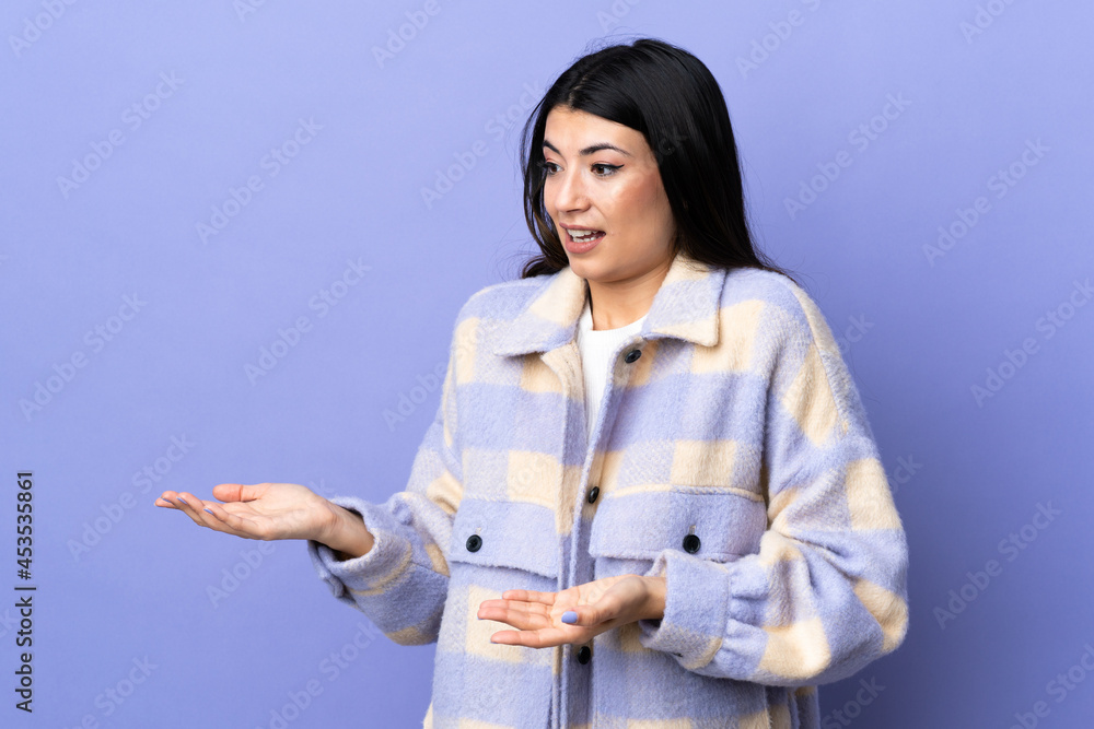 Young brunette woman over isolated purple background with surprise facial expression Young brunette woman over isolated purple background with surprise facial expression