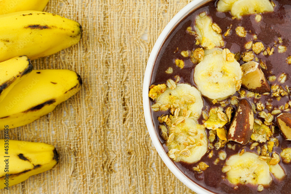 Brazilian açai in a white bowl with banana, granola and chestnuts. Brazilian açai in a white bowl with banana, granola and chestnuts.