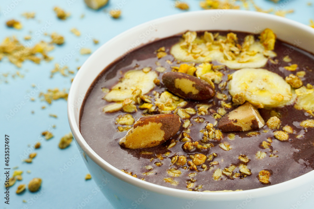Brazilian açai in a white bowl with banana, granola and chestnuts. Brazilian açai in a white bowl with banana, granola and chestnuts.