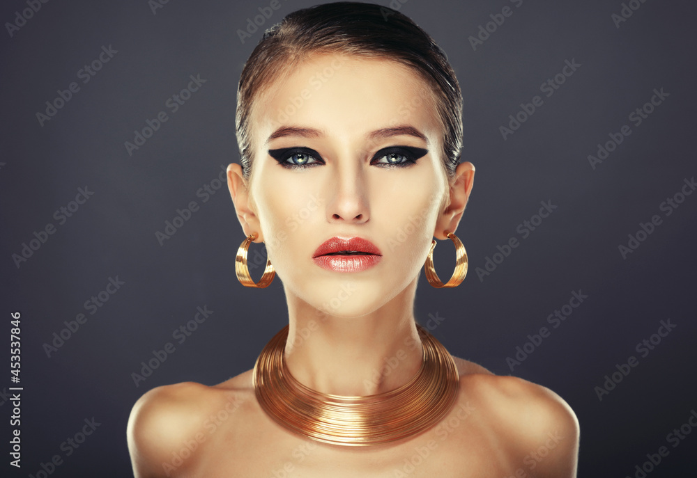 Beautiful woman with evening make-up and gold jewelry. Beautiful woman with evening make-up and gold jewelry.