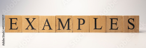 The word examples was created from wooden cubes. business and planning