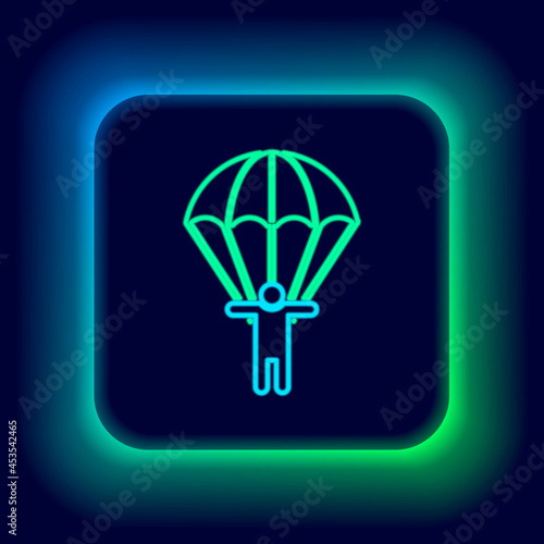 Glowing neon line Parachute and silhouette person icon isolated on black background. Colorful outline concept. Vector