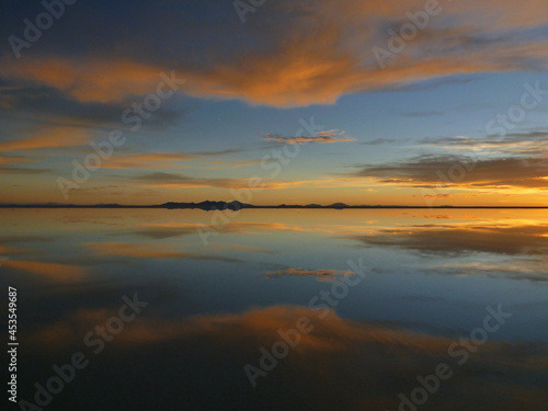 ボリビアのウユニ塩湖にて水面に鏡のように反射する夕日