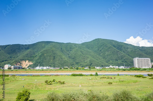 summer natural scenery seen from riverside road; mountain range and chikuma river in nagano prefecture, japan photo