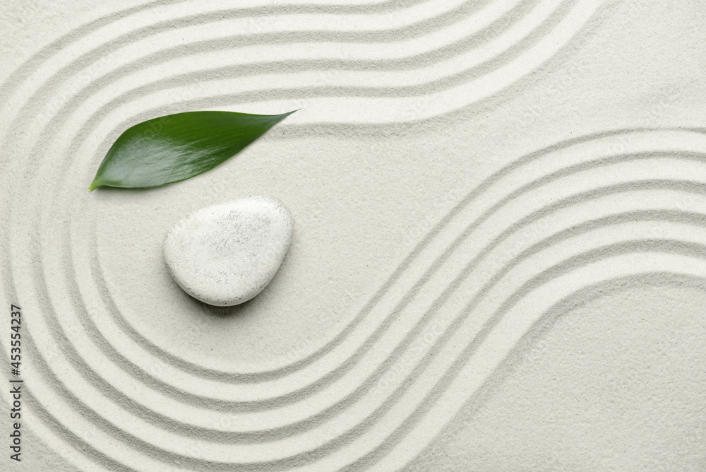 Obraz premium Stone and leaf on sand with lines. Zen concept