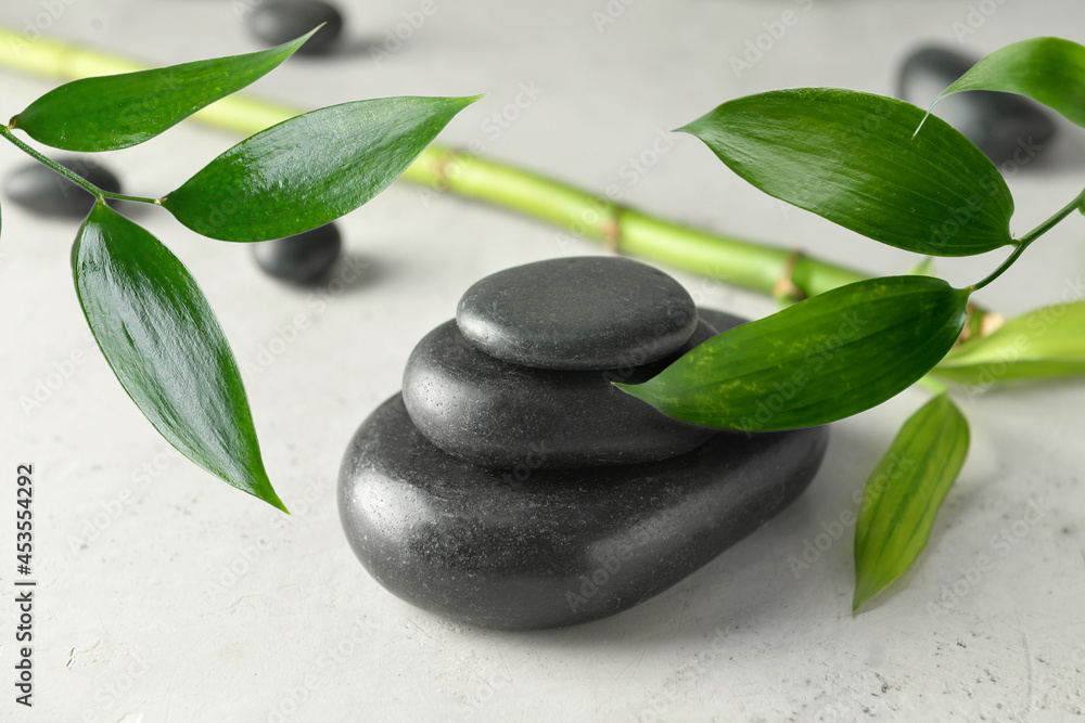 Fototapeta premium Stack of spa stones and bamboo on light background