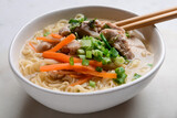 Tasty Chinese soup with chicken in bowl on light background, closeup
