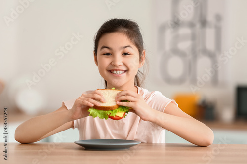 Little girl eating tasty sa...