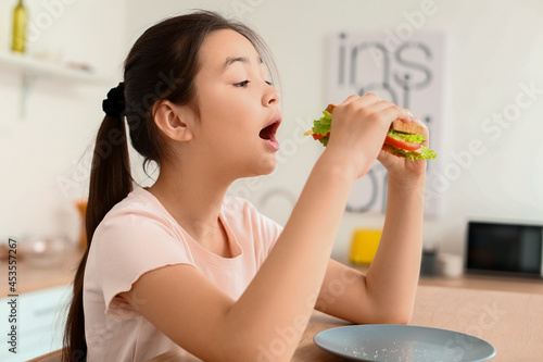 Little girl eating tasty sa...