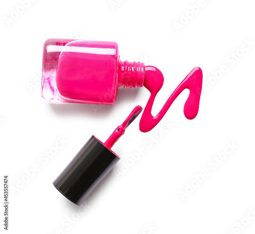 Overturned bottle of nail polish with brush and blot on white background