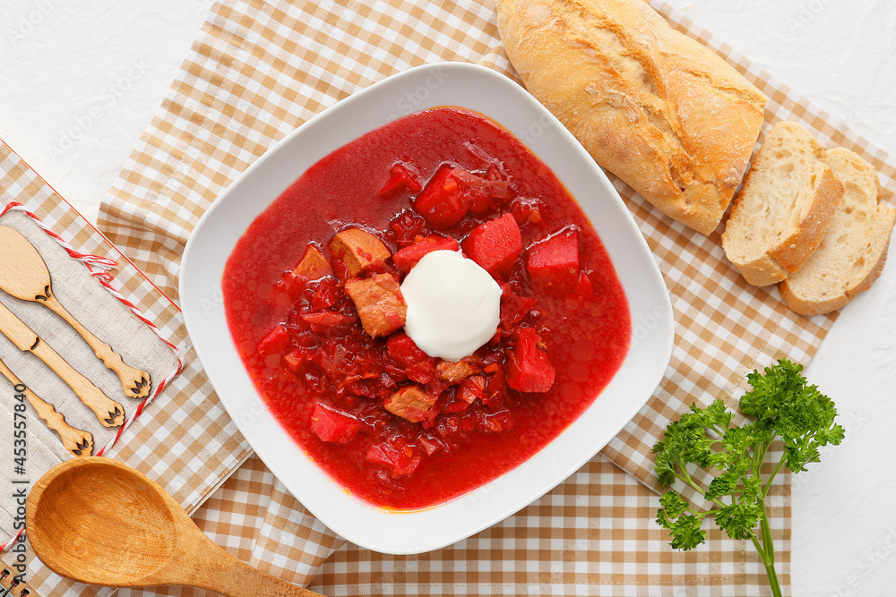 Bowl of tasty borscht with sour cream and fresh bread on light background Bowl of tasty borscht with sour cream and fresh bread on light background