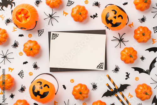Top view photo of black envelope cobweb on white card pumpkin baskets candy corn straws spiders cats witches and bats silhouettes on isolated white background with blank space