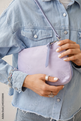 Fashionable young woman holding trendy handbag, closeup