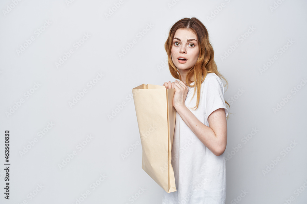 cheerful woman with a package in her hands shopping light background cheerful woman with a package in her hands shopping light background