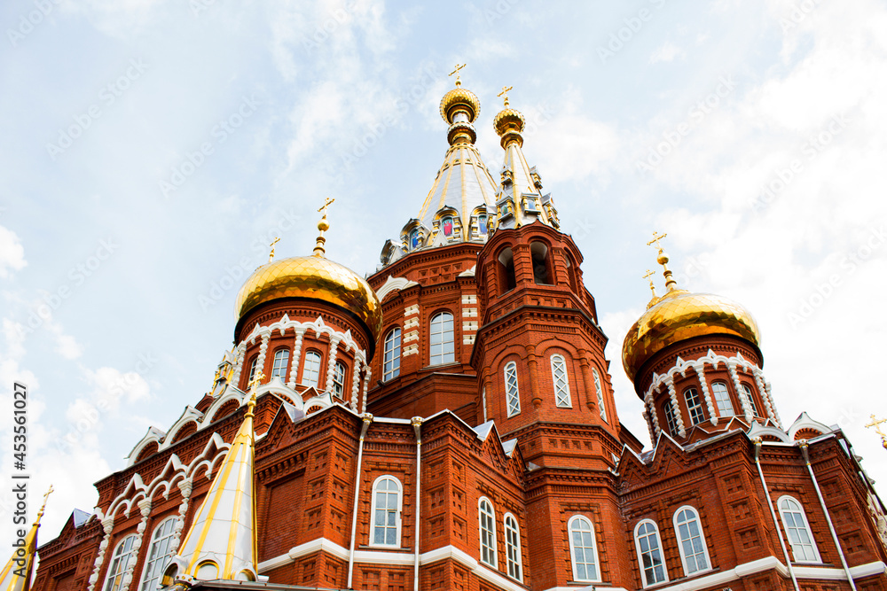 Fototapeta premium Beautiful red brick cathedral with golden domes