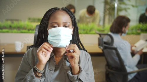 A beautiful lady is putting a protective mask on her face photo