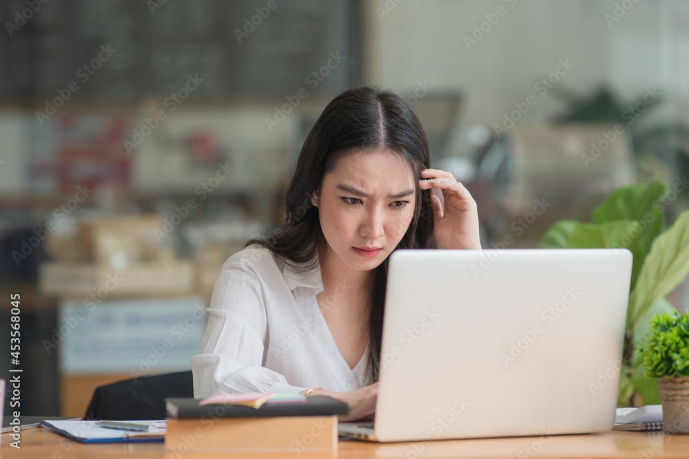 Asian businesswoman gets stressed while having a problem at work in the office.