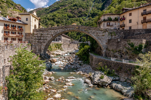 The ancient Pont Saint Martin bridge, in the historic center of the homonymous village, on a sunny day, Aosta Valley, Italy