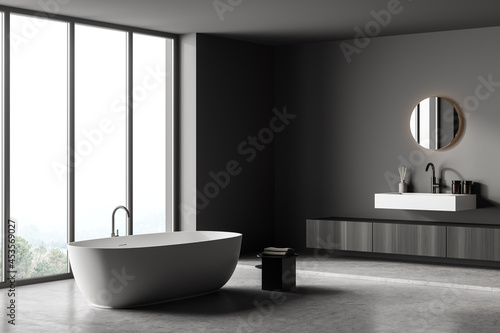 Dark bathroom interior with bathtub  panoramic window  carpet  concrete floor