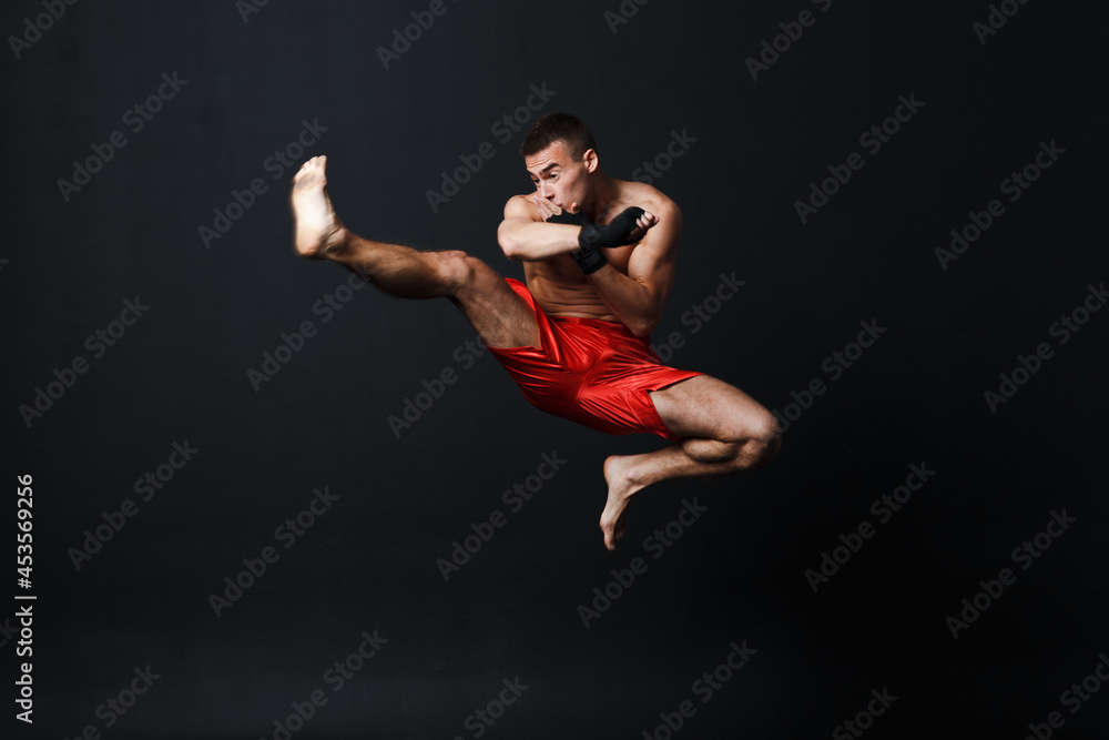Sportsman muay thai man boxer stance at black background.