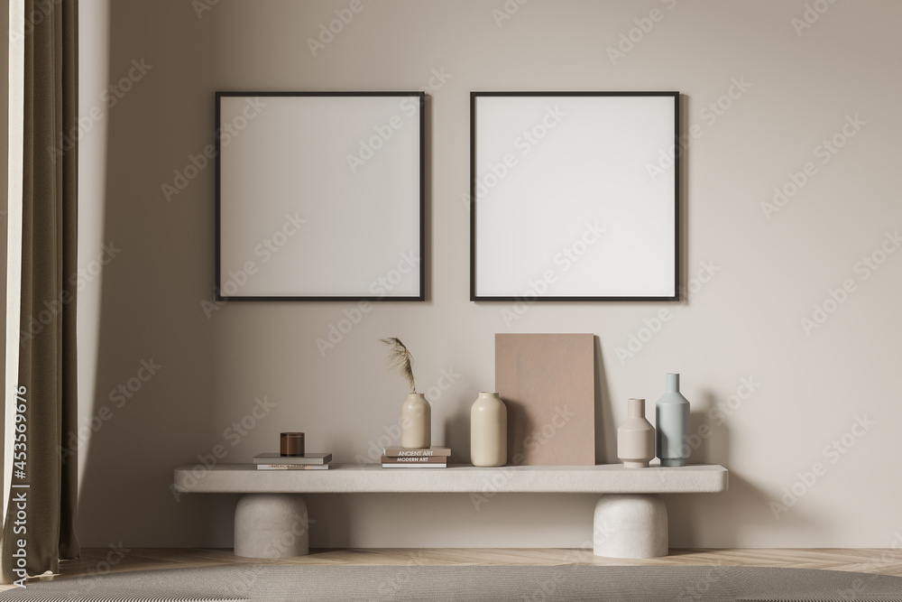 Two square posters with a bench near a beige living room wall Two square posters with a bench near a beige living room wall