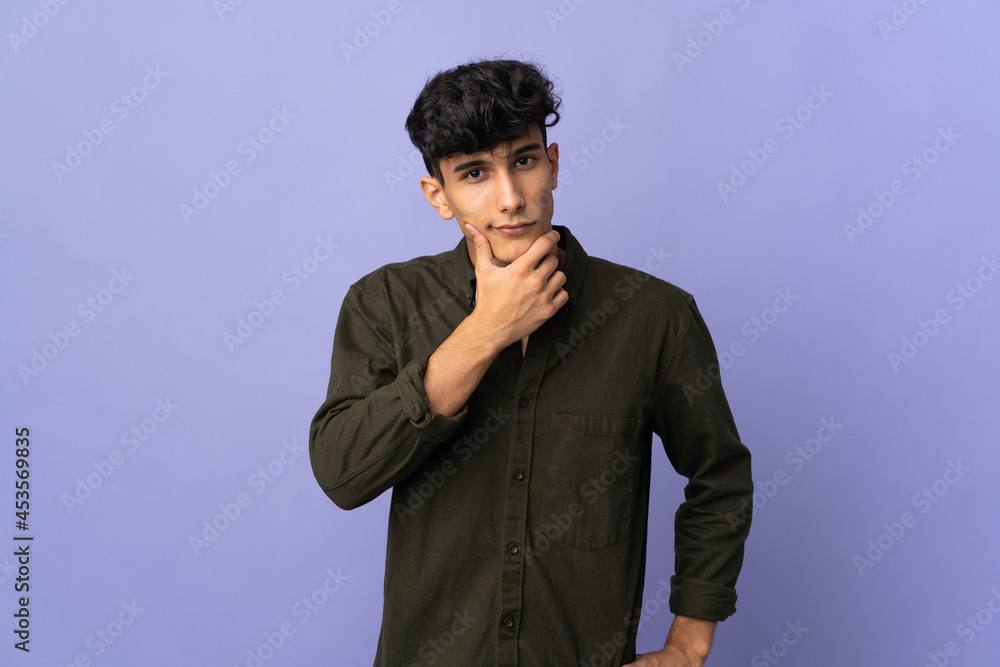 Young Argentinian man isolated on background having doubts Young Argentinian man isolated on background having doubts