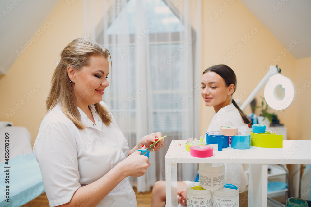 Beautiful woman applying tape lifting treatment procedure on face Beautiful woman applying tape lifting treatment procedure on face