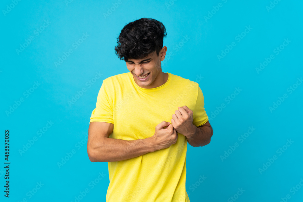 Young Argentinian man isolated on background having a pain in the heart Young Argentinian man isolated on background having a pain in the heart